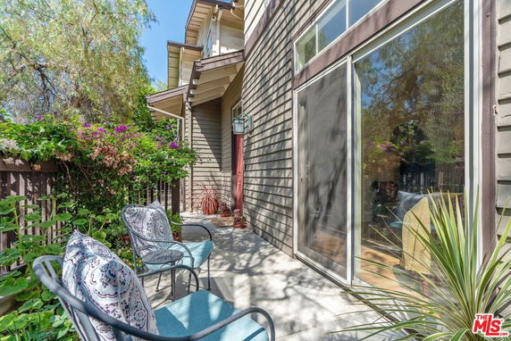 Front view of a house with a patio and chairs.