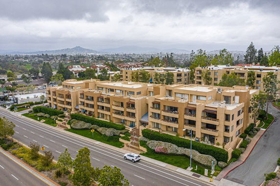 Aerial view of a multi-story apartment complex with surrounding roads and greenery.
