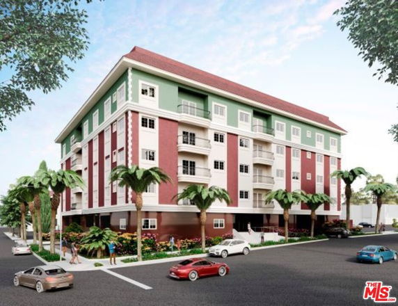 Front view of a multi-story residential building with colorful facade and balconies.