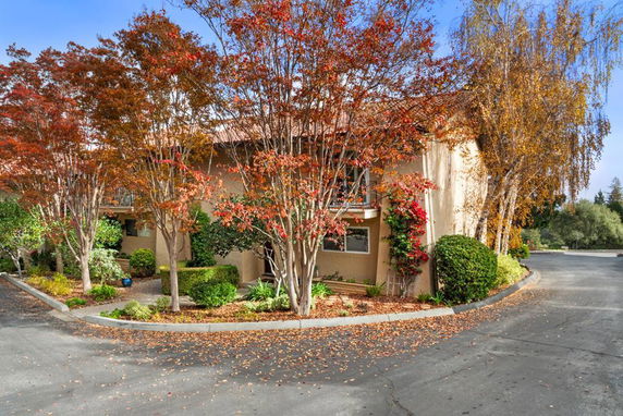 Front view of a two-story building with autumn foliage.