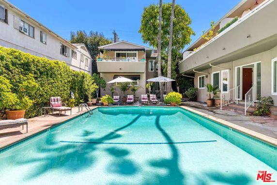 Outdoor swimming pool area with surrounding buildings.