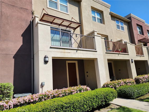 Front view of a multi-story townhouse with balconies.