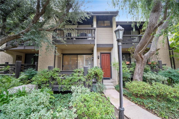 Front view of a two-story house with balconies and a central entrance.