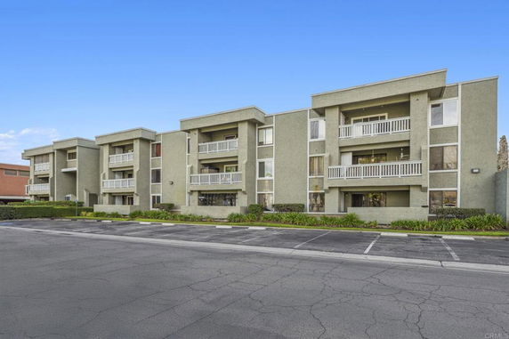 Front view of a three-story apartment building with balconies.