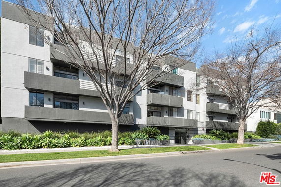 Front view of a modern multi-story apartment building with balconies.