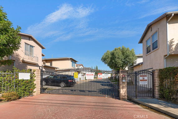Front view of a gated residential complex with multiple two-story houses.