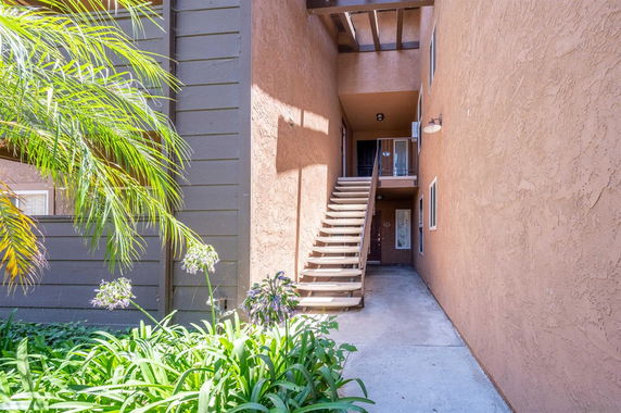 View of a building entrance with an outdoor staircase leading to the upper level.