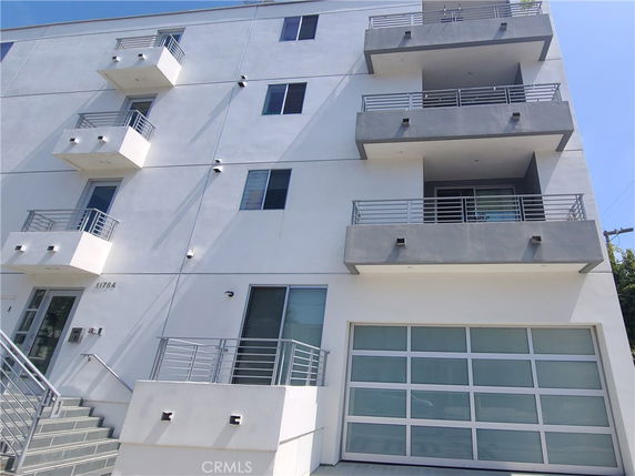 Front view of a modern multi-story building with balconies.