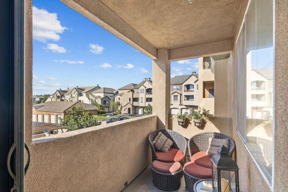 View from a balcony overlooking a residential area with multi-story buildings.