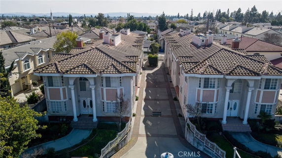 Front view of large multi-story buildings with tile roofs and columns.