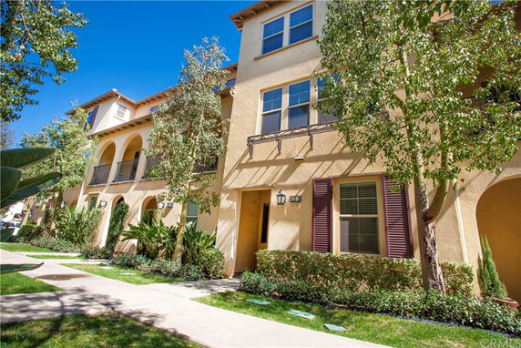 Front view of a multi-story residential building with balconies and arches.