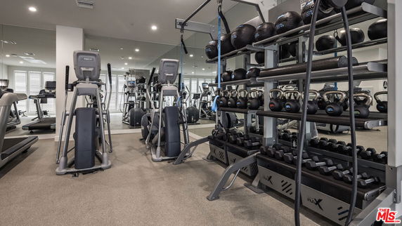 Indoor gym area with exercise equipment and weights.