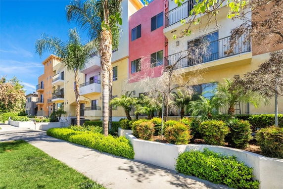 Front view of a multi-story residential building with balconies and colorful facade.