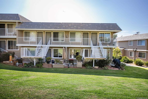 Front view of a two-story house with exterior stairs and balconies.