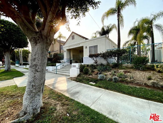 Front view of a building with steps and a small garden area.