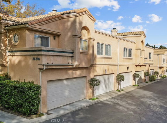 Front view of a two-story townhouse with a double garage.