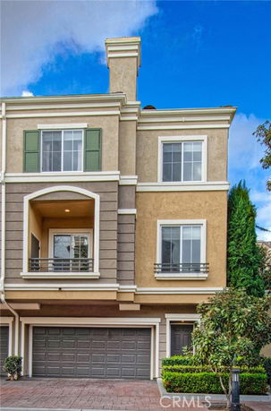 Front view of a three-story house with a double garage and balcony.