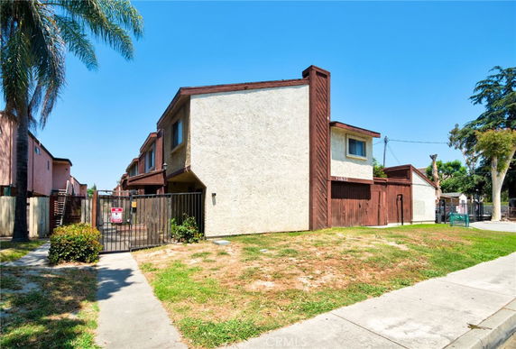 Front view of a two-story residential building with gated entry.