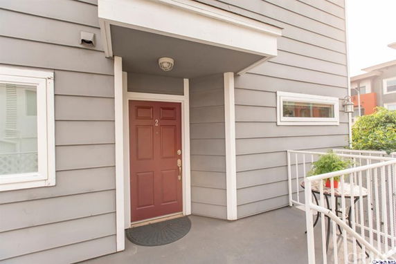 Front view of a building with a red door and gray siding.