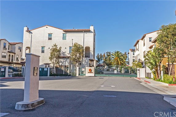 Front view of a multi-story residential building with gated entrance.