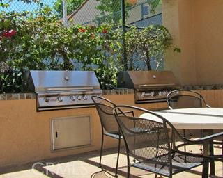 Outdoor patio area with built-in grills and seating.