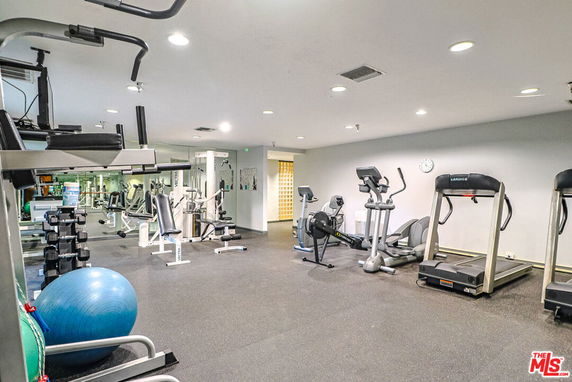 Indoor gym area with various exercise equipment including treadmills and weight machines.