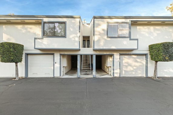 Front view of a two-story building with garages and a stairway in the center.