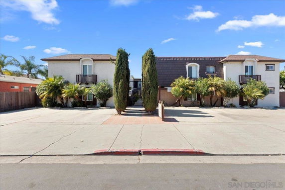 Front view of a two-story residential building with a central courtyard and minimal landscaping.