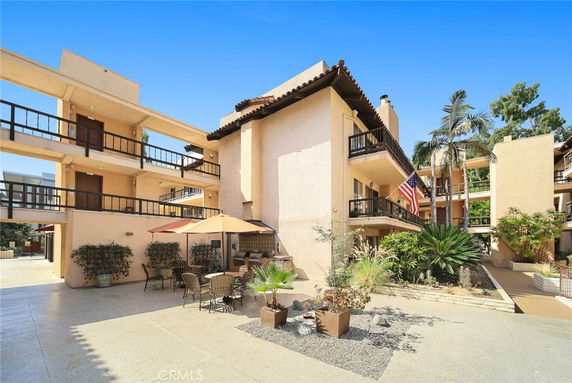 Front view of a multi-story building with balconies and a central courtyard.