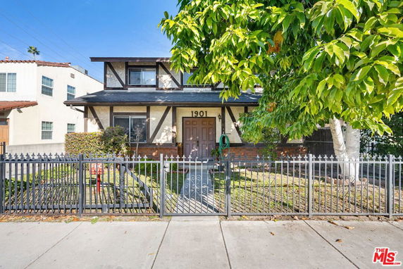 Front view of a two-story house with a gated front yard.