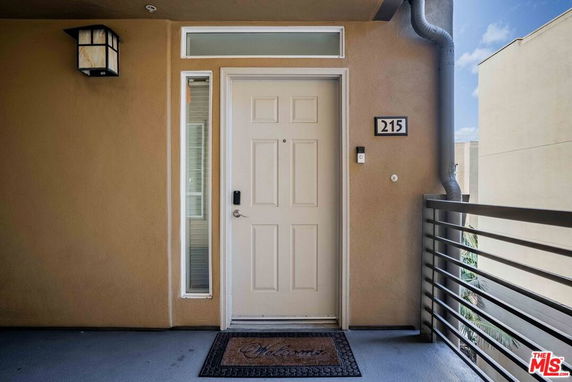 Front view of a doorway with an adjacent wall and a railing.