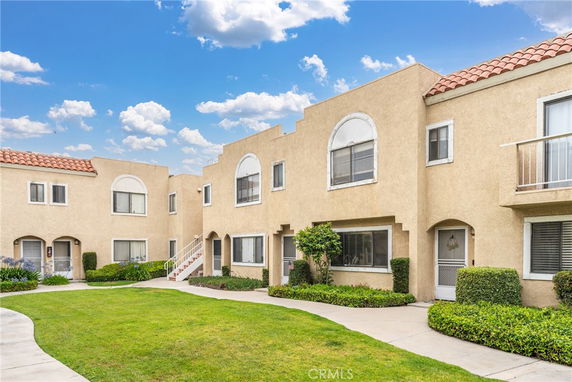 Front view of two-story residential buildings with arched windows and doors.