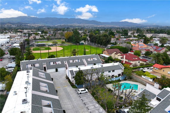 Aerial view of a residential complex with nearby baseball field and mountains in the background.