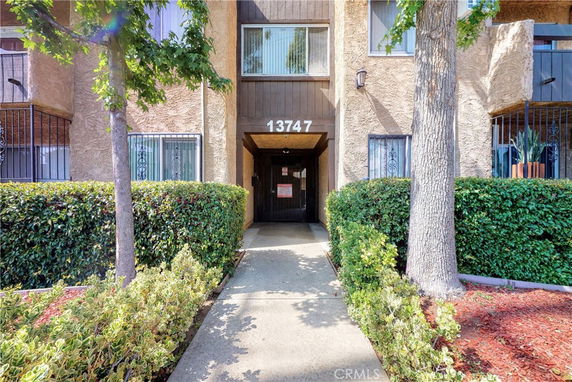 Front view of a multi-story building entrance with a walkway.