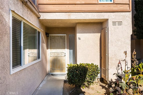 Front view of a house entrance with a security door and adjacent window.