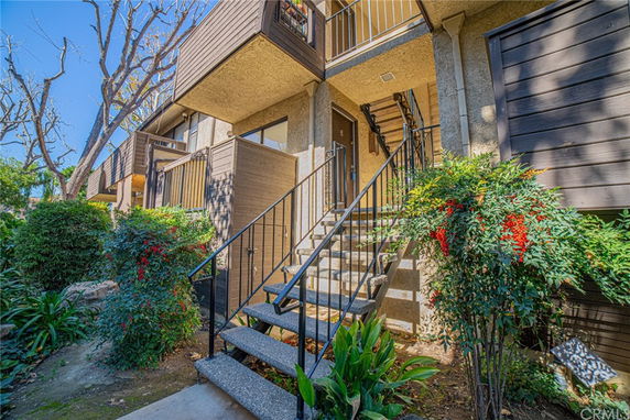 Front view of a multi-story residential building with stair access and balconies.