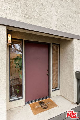 Front view of a house entrance with a red door and side windows.
