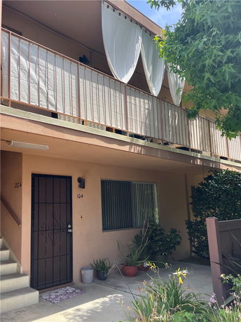 Front view of a two-story apartment building with a balcony and curtain.