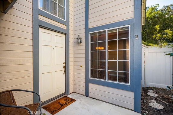 Front view of a house entrance with a window and a light fixture.