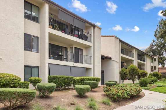 Front view of a multi-story apartment building with balconies.