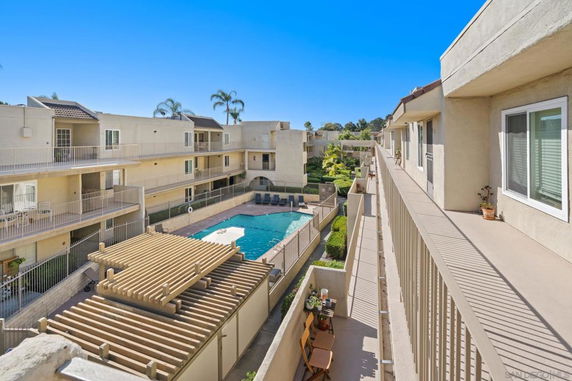 View from a multi-story apartment complex showing a central swimming pool and surrounding balconies.