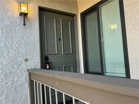 Entrance view of a residential building with a green door and window.