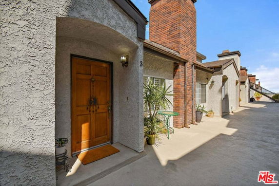 Front view of a house entrance with a wooden door and brick accents.
