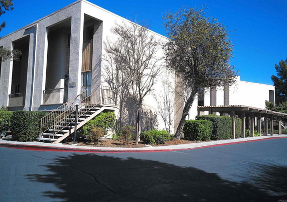 Front view of a building with stairs and tall pillars.