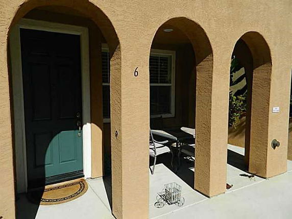 Front view of a house with a covered entrance and arched columns.