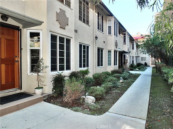 Front view of a multi-story residential building with a walkway.
