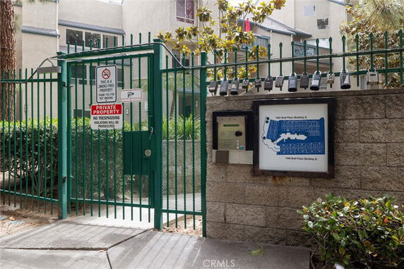 Front view of a building with green fencing and a gated entrance.