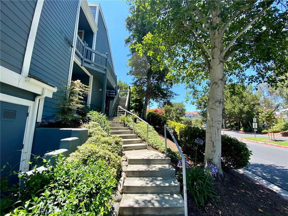 Front view of a multi-story building with stairway access and blue siding.
