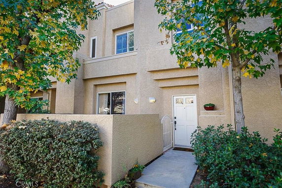 Front view of a townhouse with a white door and small gated entrance.