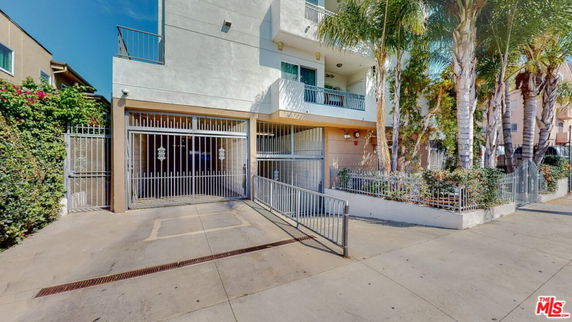Front view of a multi-story building with gated entrances.